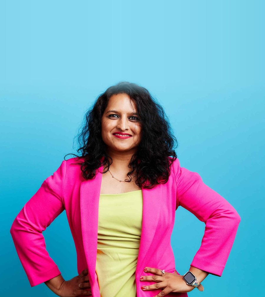 Pranjal Ranka in a pink blazer, smiling with hands on hips